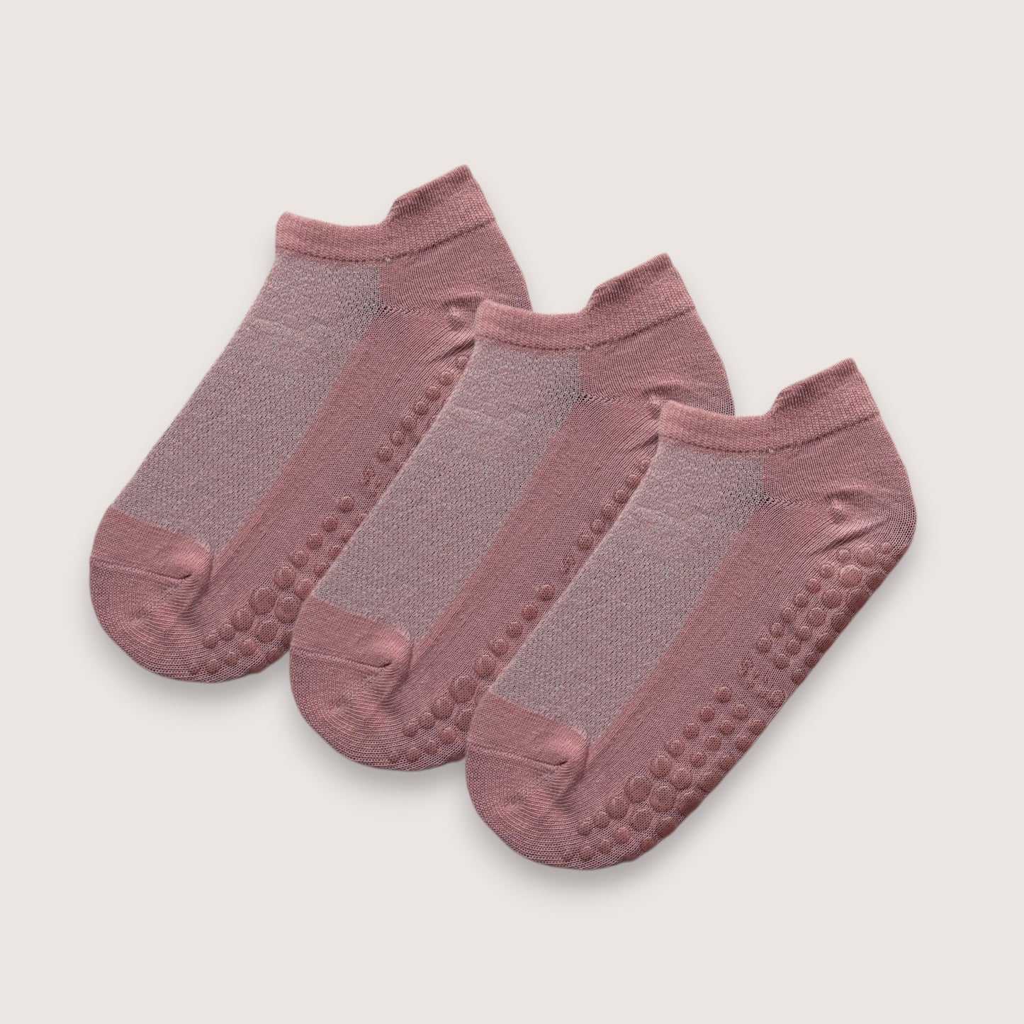 tre stycken rosa ankelstrumpor med halkskydd mot vit bakgrund
