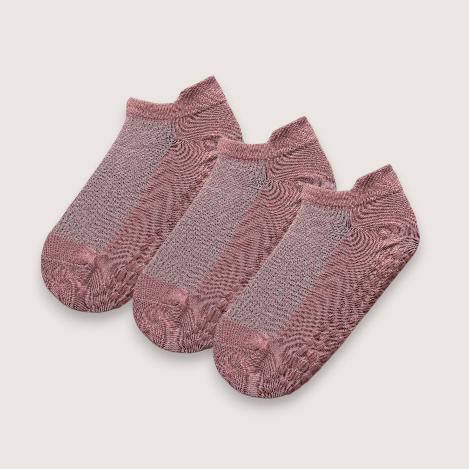 tre stycken rosa ankelstrumpor med halkskydd mot vit bakgrund